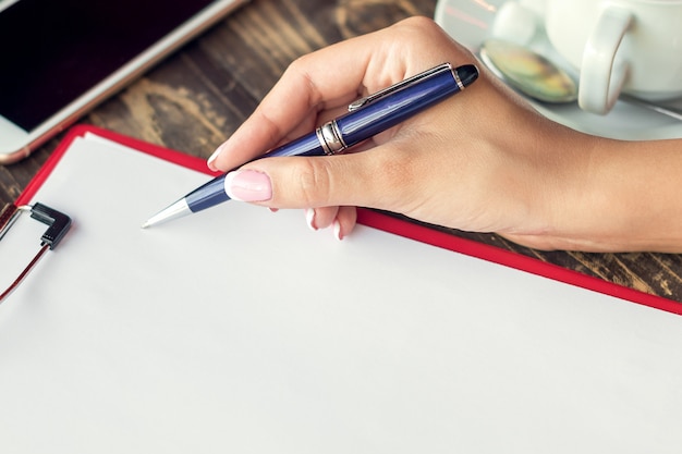 A close-up shot of hands signing a legal document with a pen. The document is an estate planning document with the words 