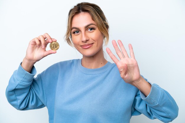 A close-up of a hand holding a coin, with blurred background of various emotional faces, symbolizing the emotional impact that money has on people.
