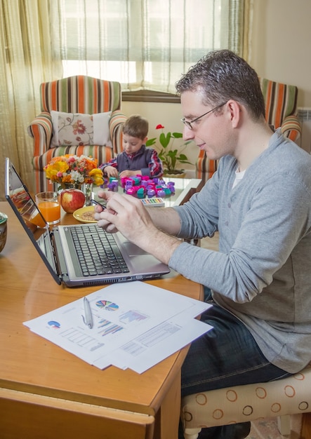 A family planning their finances around a table, with childcare expense charts and a calculator, emphasizing the strategic planning needed for Dependent Care FSA contributions.