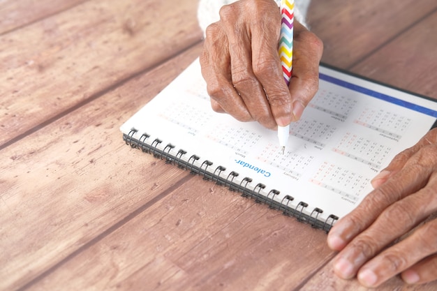 A person filling out an enrollment form for a Dependent Care FSA, with a calendar in the background highlighting the open enrollment period, emphasizing the timely action required for enrollment.