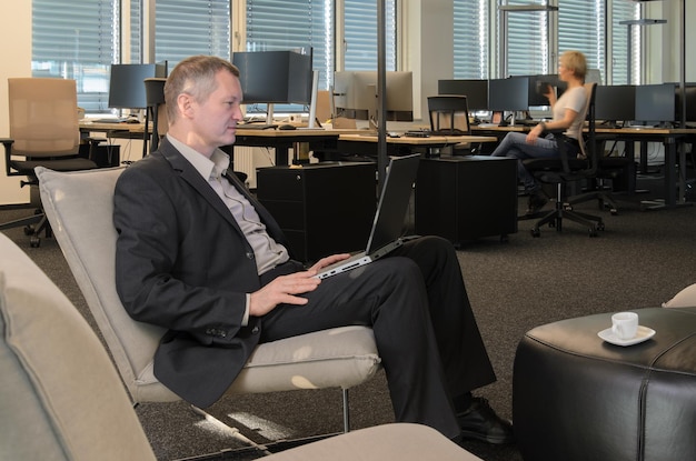 An employee confidently using a laptop in a quiet office space, accessing their company's EAP portal. The screen displays a user-friendly interface with options for counseling, resources, and contact information.