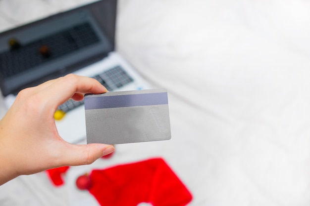 A close-up of HSA debit card in a person's hand, focus on tax benefits of HSA, blurred background.