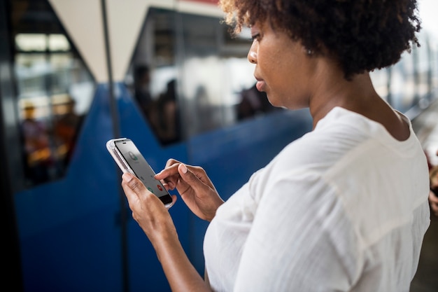 A person holding a smartphone with a commuter benefits app open, showing transit options and account balances, indicating ease of use and management.