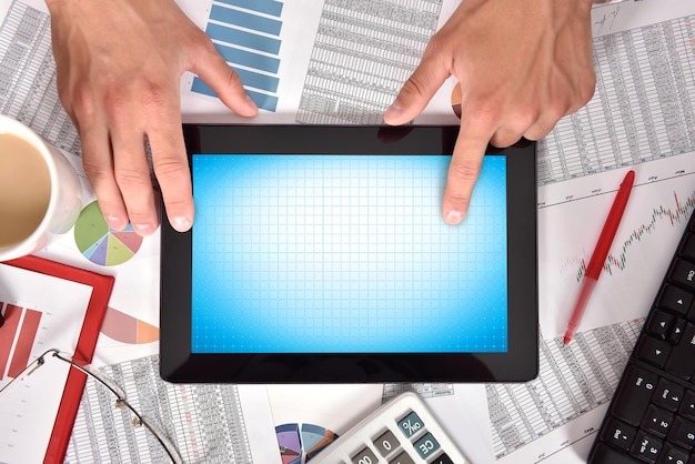 A person using a financial calculator with various charts and graphs on the screen, highlighting the importance of using tools and resources to accurately calculate retirement savings goals.