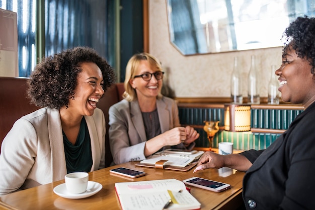A diverse group of people gathered around a table, smiling and engaged in a financial planning meeting. The setting should evoke feelings of collaboration, confidence and financial empowerment.