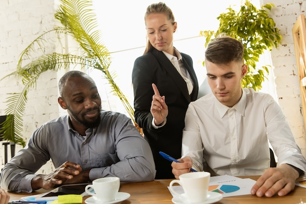 A diverse group of people discussing investment strategies and risk factors around a table, emphasizing collaborative financial planning and understanding different risk perspectives.