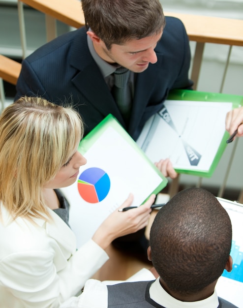 A person attending an investment seminar, actively taking notes and engaging with the speaker, indicating a commitment to learning about financial strategies and risk management.