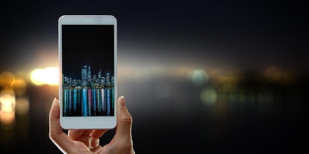 A close-up of a smartphone screen displaying a brokerage app interface with stock charts and account details visible, set against a blurred background of a bustling cityscape.