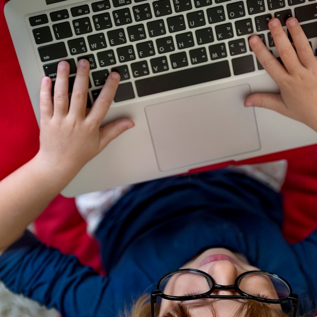 Close-up of hands typing on a laptop with a stressed expression in the background, symbolizing the challenges of student loan applications.