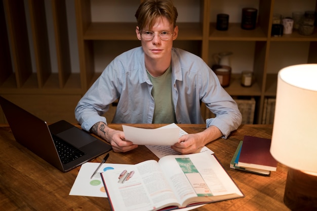A person sitting at a desk, reviewing documents related to taxes and education expenses. The scene is well-lit and focused on the paperwork.