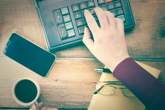 A close-up image of a hand holding a calculator, with a state tax form partially visible in the background. The image symbolizes calculating and understanding state tax benefits.
