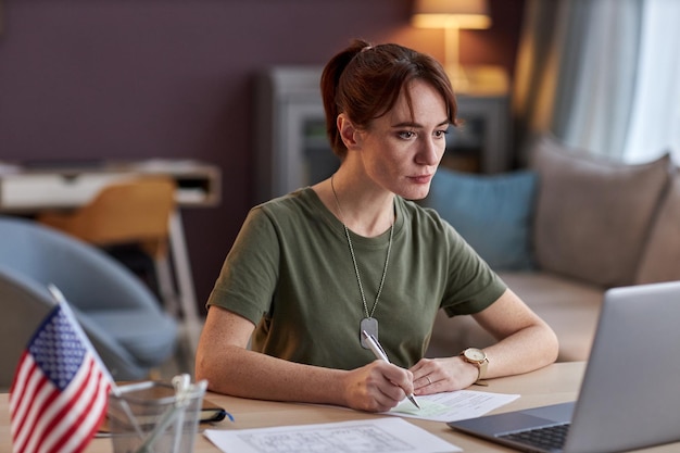 A close-up shot of a student meticulously researching scholarship opportunities on a laptop, highlighting their focused attention and determination. A stack of books is subtly blurred in the background, emphasizing the academic environment.