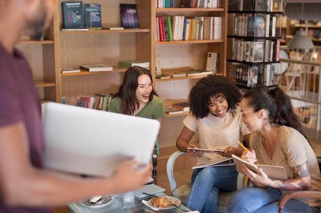 A diverse group of students working collaboratively on a scholarship application in a library setting, emphasizing teamwork and the value of peer support. Soft, natural lighting.