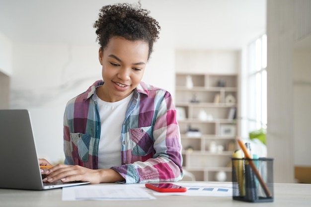 A person smiling while working on their laptop, showing how education tax credits can reduce financial stress and allow students to focus on their studies.