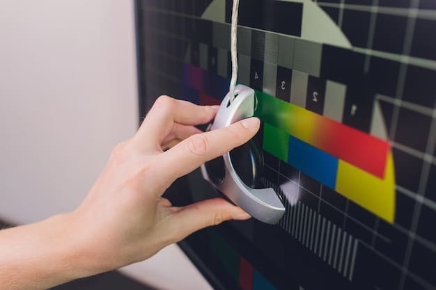 A colorimeter device attached to the screen of a monitor, measuring the color output. The display shows calibration software with various readings and settings.