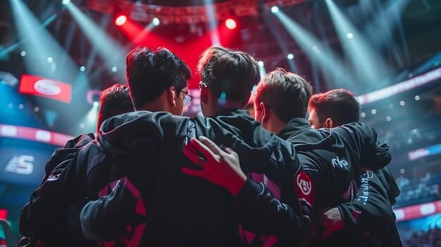 Action shot of a US college esports team in the middle of a competitive match playing League of Legends. The players are focused and intense, communicating quickly, captured from behind and slightly above. The stage is well-lit with the crowd blurred in the background, cheering excitedly.