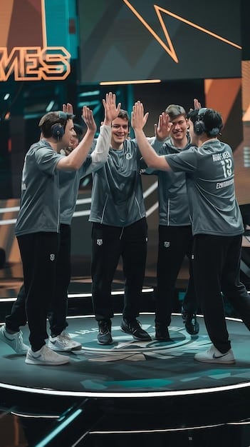 A close-up shot of two esports team members high-fiving after a successful play during a tournament. The team jerseys are visible and branded.